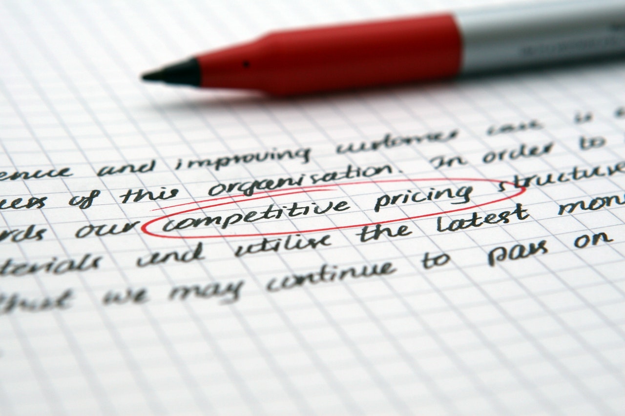 Handgeschreven notitie met de woorden competitive pricing rood omcirkeld