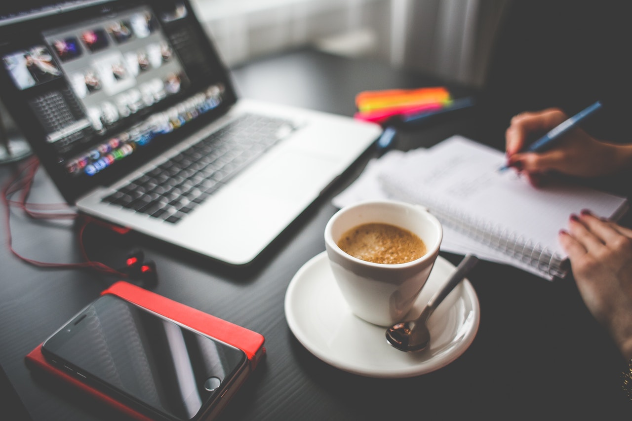 Werkplek met laptop, kop koffie en notitieboek