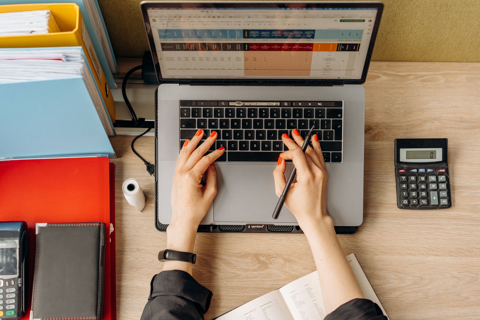 Bureau met laptop, rekenmachine en ordners: de administratie van betalingen en incasso's