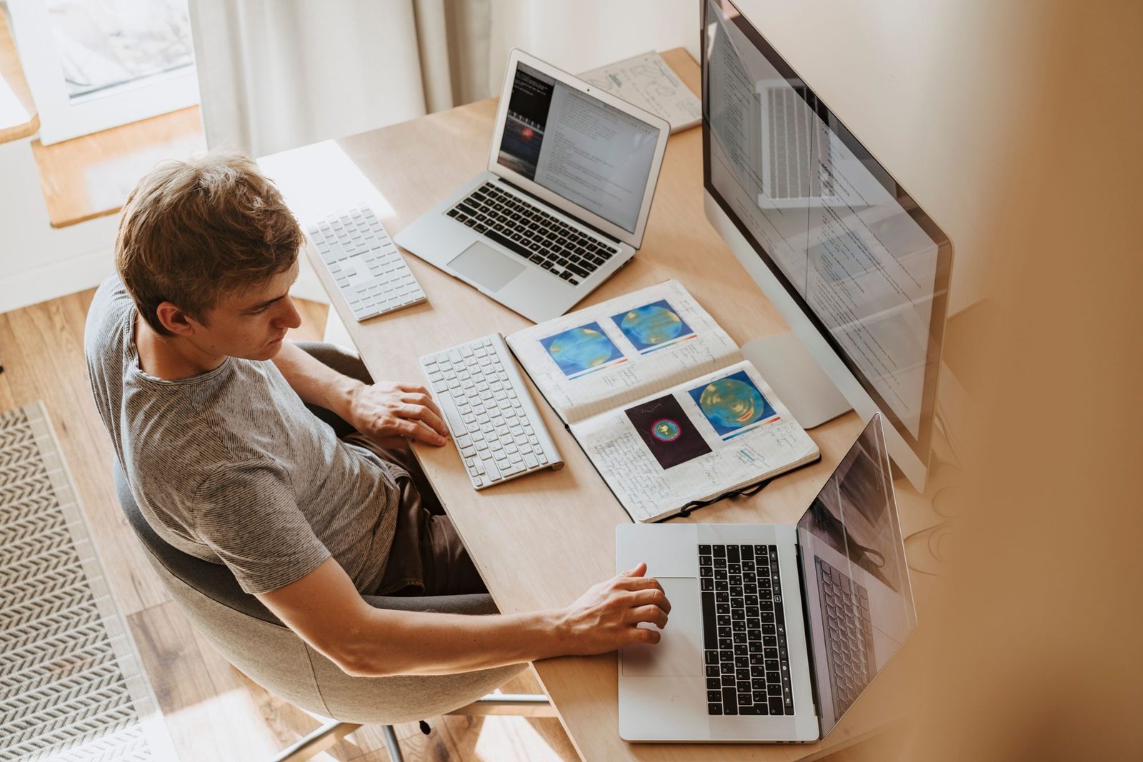 Ondernemer aan een bureau met laptops en een beeldscherm: SEPA-bestanden klaarmaken voor de bank
